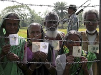 Indians standing outside of the International Barbed Wire Border Fence