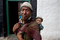 An old Loba man holds her grandson and poses for a picture .