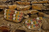 Sacred Tibetan religious text scripted in stones, a common Tibetan Buddhism practice.